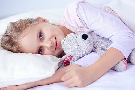 小女孩睡在床上 跟玩具泰迪熊睡觉女孩卧室女性童年毯子枕头孩子就寝寝具时间图片