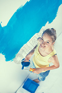 做墙壁绘画的年轻美女家庭作业工作房屋蓝色女孩滚筒工人染料房子刷子图片