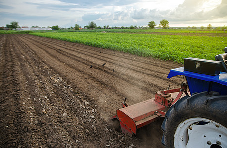 一台带铣床的拖拉机正在耕种农田 用中耕机耕种后松散的湿润土壤 疏松地表 开垦土地 农业 使用农业机械图片