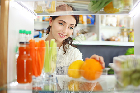 女性在露天冰箱附近站立的肖像 上面装满了健康的食品 蔬菜和水果图片