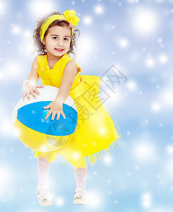 穿黄色礼服的小女孩拿着球教育儿童卷曲白色女孩婴儿房间孩子们幼儿园学校图片