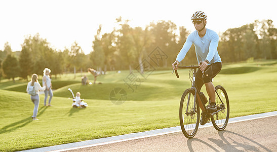 积极的生活方式 日落时 身着运动服和防护头盔的年轻运动员在公园骑山地自行车图片