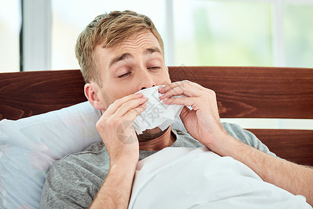 照顾好你自己 一个生病的年轻人的画像 流鼻涕患感冒或流感 躺在家里的床上打喷嚏 病毒病图片