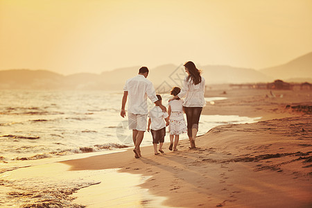 快乐的年轻家庭 在日落时在海滩上玩得开心天空跑步妈妈海洋儿子爸爸热带女性太阳女孩图片