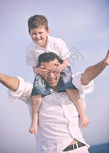 快乐的父亲和儿子玩得开心 在海滩上享受时光家庭闲暇成人父母男人男性海滨时尚喜悦微笑图片