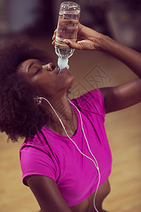 在健身房的年轻美籍女子 有小儿科锻炼课间休息音乐瓶子微笑饮食运动女性呼吸运动装手机身体图片