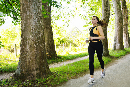 清晨在公园慢跑的年轻美女跑步运动慢跑者闲暇活力运动员活动赛跑者女孩行动图片