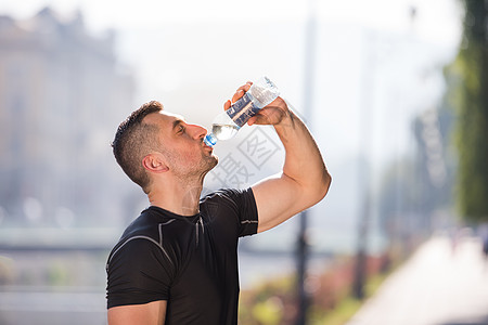 男子慢跑后从瓶子里喝水活力身体男人男性训练晴天城市茶点运动装运动图片