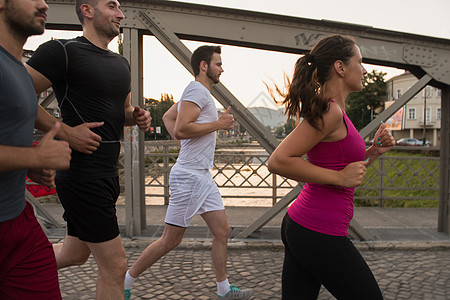 一群年轻人在桥上慢跑男性重量运动城市赛跑者街道晴天活力女性团体图片