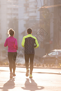 年轻夫妇慢跑训练女士跑步者男人耀斑夫妻运动太阳公园卷曲图片