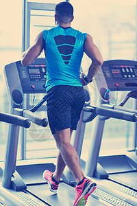 男人在跑步机上奔跑培训师成人身体训练男性拉丁运动员运动服护理跑步图片