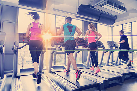 一群人在跑步机上奔跑体育馆跑步女孩运动赛跑者培训师团体男性朋友们有氧运动图片