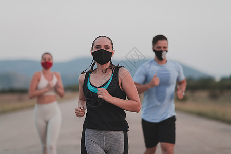 多族裔赛跑者群体戴面罩 在户外保持社会距离 健康 多样化的团队晚上穿着运动服慢跑参加自然体育赛道 为了安全而分心成人运动幸福活动图片