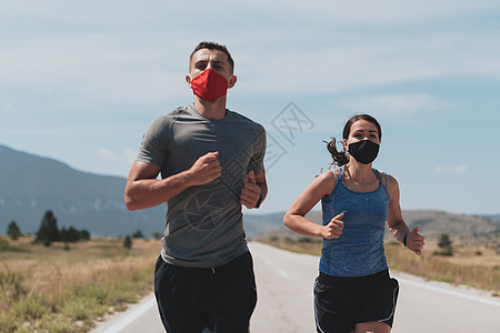 早上 戴着防护面具的年轻男女在户外跑步和锻炼 运动 积极的生活在检疫期间慢跑 Covid19 新常态 选择性的焦点城市男人赛跑者图片