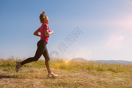 女青年慢跑太阳耀斑女性国家赛跑者运动装慢跑者跑步日落女孩图片