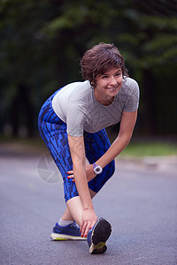 女人在早晨慢跑前伸展运动员身体女孩成人公园跑步赛跑者娱乐电话运动图片