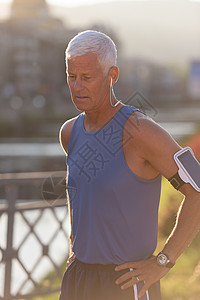英俊的高级慢跑运动员肖像锻炼阳光男性退休晴天闲暇跑步蓝色天空快乐图片
