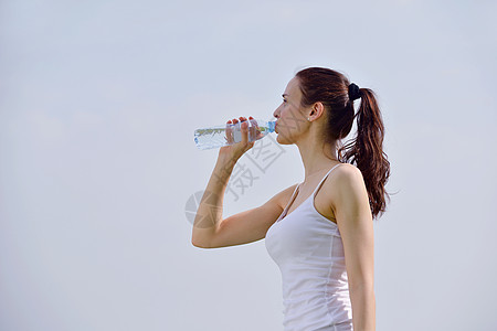 年轻美容女子健身后饮用水的锻炼活动成人慢跑者运动装闲暇赛跑者身体跑步运动员口渴公园图片