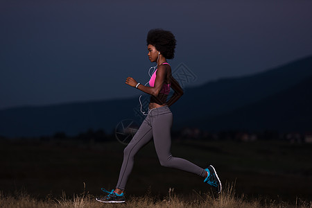 非洲女青年在自然界中慢跑草地跑步训练慢跑者运动活力娱乐健康赛跑者音乐播放器图片