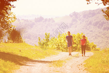 年轻夫妇在大自然阳光明媚的日子慢跑夫妻朋友们女孩跑步运动装活动训练女性公园男性图片
