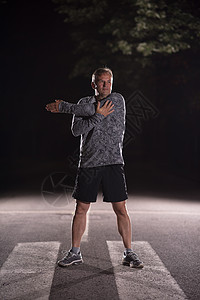高级跑者在夜间训练前升温和伸展有氧运动城市公园运动员慢跑者男人运动身体跑步森林图片