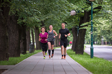 早上训练赛跑队街道公园成人行动培训师运动装运动员健康赛跑者微笑图片