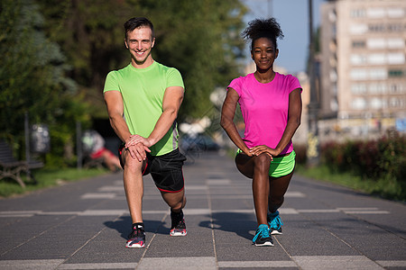 在城市里慢跑的情侣 热暖和伸展赛跑者女性女士女孩公园夫妻男性男人训练运动员图片