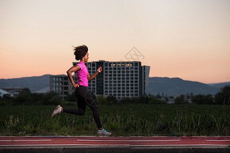 一名非洲裔美国年轻女子在户外慢跑微笑跑步运动运动员娱乐城市运动装女性赛跑者身体图片