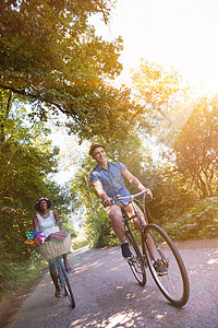 具有自然骑自行车的多种族年轻夫妇太阳男生活动运动骑术夫妻男人朋友们女士乐趣图片