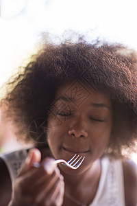 一位年轻的非裔美国女人 吃意大利面粉玻璃蔬菜美食香菜桌子油炸饮食盘子午餐餐厅图片