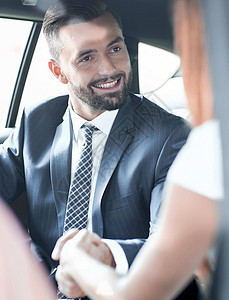 一个女人在车里的笑容很吸引人的工作阳光黑发奢华人士个性乘客窗户相机裙子商务图片