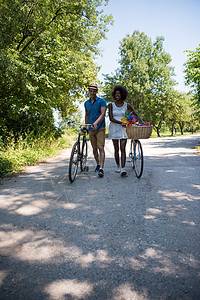 具有自然骑自行车的多种族年轻夫妇成人闲暇女性朋友们公园活动森林运动男生农村图片