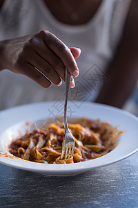 一位年轻的非裔美国女人 吃意大利面粉女士餐厅烹饪植物面条盘子美食饮食香菜文化图片