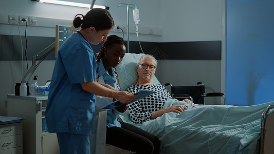 非裔美国医生在床上与生病病人交谈图片