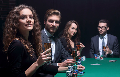 坐在赌场桌边的漂亮美人派对游戏投注朋友们乐趣裙子胜利筹码优胜者成人图片
