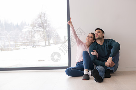 年青夫妇坐在家庭窗户旁边的地板上房间女朋友感情幸福男朋友女士丈夫地面闲暇男人图片