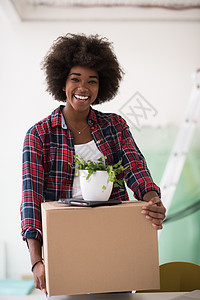 黑女孩搬进新公寓盒子成人微笑女孩房间纸盒运输财产女士幸福图片