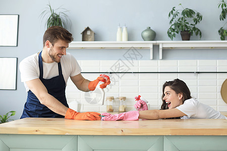 快乐的年轻夫妇在家打扫时玩得很开心家庭丈夫唱歌工作抹布家政女性妻子夫妻男性图片