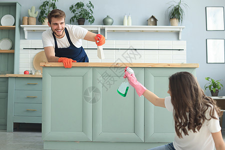 快乐的年轻夫妇在家打扫时玩得很开心家庭工作服务唱歌女孩清洁工抹布夫妻厨房微笑图片