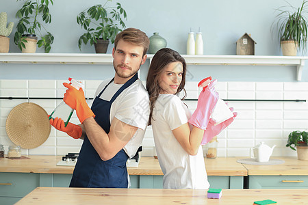 快乐的年轻夫妇在家打扫时玩得很开心洗涤剂清洁工唱歌工作夫妻帮助成人男人家务妻子图片