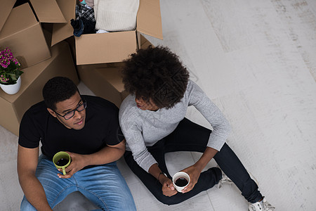 非裔美国人夫妇在新房子里放松咖啡地面盒子开箱房间杯子女性纸板财产纸盒图片
