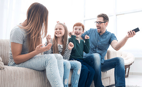 快乐的家庭坐在家中看电视时图片