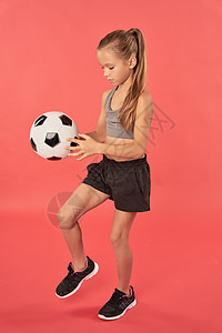 玩足球的时装运动型女子图片