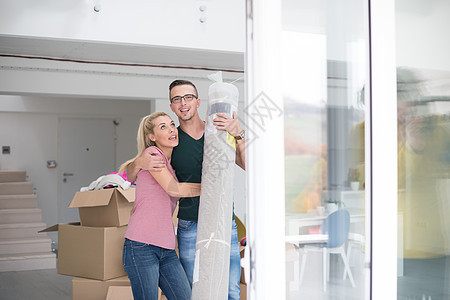 一对夫妇携带地毯搬进新家财产已婚公寓女士微笑夫妻盒子丈夫幸福客厅图片