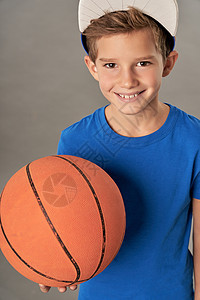 穿着蓝衬衫 拿着篮球的快乐男孩图片