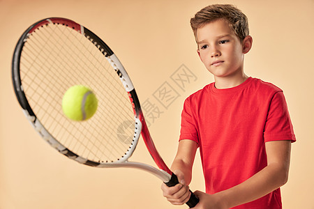 穿红衬衫打网球的可爱男孩图片