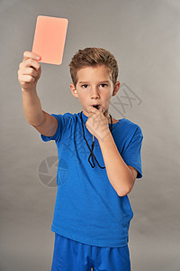 带着红卡和吹口哨的可爱男孩裁判图片