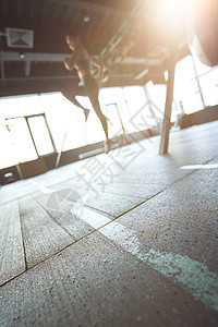 体育培训概念 在工业健身房工作时 运动女运动员穿运动服的垂直镜头 以地面为重点图片