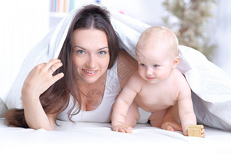 幸福的母亲和躺在床上的婴儿玩耍喜悦探索孩子团聚休息欢呼活动枕头母性毯子图片