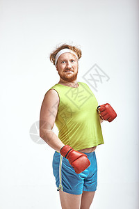 穿着运动服和红色拳击手套的红头发 胡子 大胡须 胖子肥胖饮食损失运动装管状动机健身房身体男性重量图片